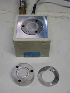 Photograph of the PAV cell. The top plate is shown in front of the cell together with one of the stainless steel microfoil spacing rings.